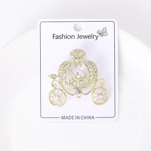 Detailed view of fairytale pumpkin carriage brooch with sparkling rhinestones in gold