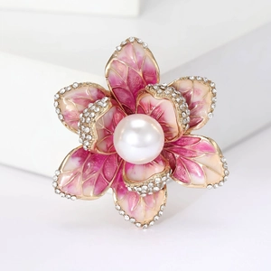 Macro shot of elegant enamel begonia brooch with pink petals, crystals and center pearl