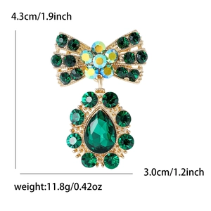 Détails et dimensions d'une broche nœud en alliage doré avec des cristaux verts vintage