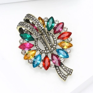 Detail view of vintage marquise brooch featuring colorful gemstones and crystal pavé on gold base