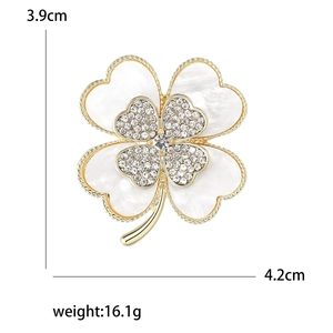 Sparkling four-leaf clover brooch with white mother of pearl and crystals in gold setting