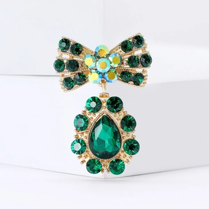 Élégante broche nœud dorée avec strass vert émeraude et pendentif en cristal en forme de poire