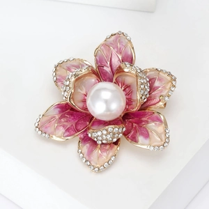 Detailed macro view of enamel flower brooch with pink petals and a large center pearl