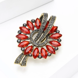 Detailed macro view of vintage flower brooch with red marquise crystals and golden alloy