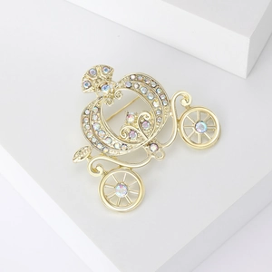 Fairy tale style golden pumpkin carriage brooch with colorful rhinestones on white display