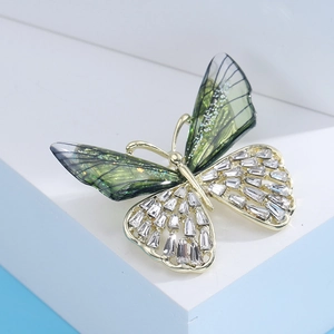 Macro detail of butterfly brooch with green gradient wings and inlaid zircon crystals
