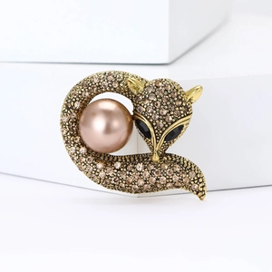 Détail de la broche renard aux cristaux champagne et grande perle rose sur or