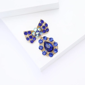 Détail de broche nœud vintage avec strass bleus et pendentif en forme de goutte