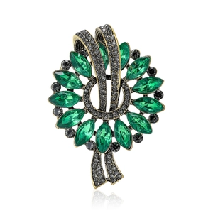 Vintage marquise emerald green floral brooch with bronze alloy base on white background