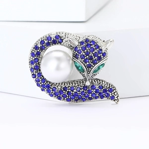 Broche renard en cristal bleu avec perle blanche sur fond géométrique moderne