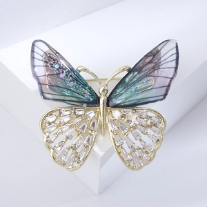 Detailed macro of crystal butterfly brooch with gradient wings and gold plating