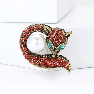 Broche renard élégante avec strass rouges, yeux verts et une grande perle blanche