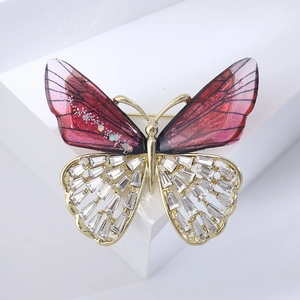 Detailed close-up of butterfly brooch with red resin wings and rectangular crystals