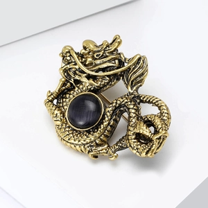 Macro shot of vintage dragon brooch with gold scales and a centered black gemstone