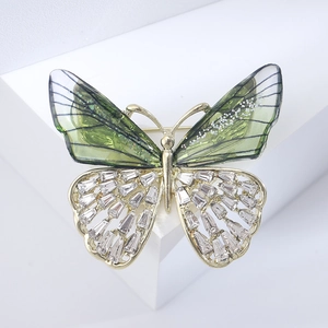 Detailed macro view of the butterfly brooch with green wings and inlaid crystals