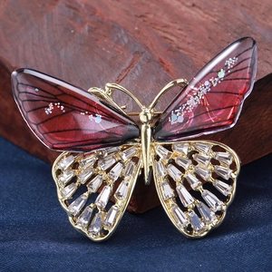 Macro shot of gradient rhinestone butterfly brooch with golden wings and crystals