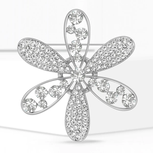 Vue macro d'une broche fleurie argentée avec strass et pierre centrale ronde