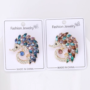 Detail view of two creative hedgehog brooches with colorful rhinestones on display cards