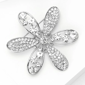 Détail macro d'une broche fleur argentée ornée de strass étincelants et de cristaux