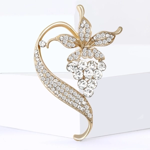 Elegant gold vine brooch with sparkling rhinestones on a white minimalist background