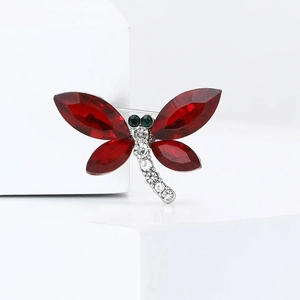 Détail de la broche libellule avec pierres marquises rouges et strass blancs sur blanc