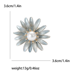 Detail showing blue daisy brooch with pearl center and 3.6cm gold-edged petals
