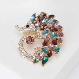Exquisite gold hedgehog brooch with colorful crystals and rhinestones on a white pedestal