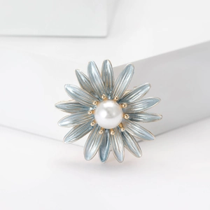 Detailed close-up of a floral brooch with light blue petals and a central white pearl