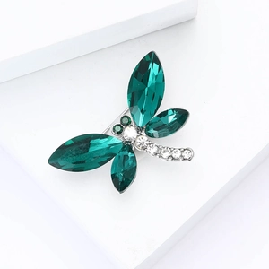 Détail de la broche libellule aux ailes de cristal vert et aux strass étincelants