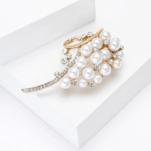 Close-up of luxury pearl brooch with gold alloy base and sparkling rhinestones