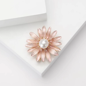 Detailed close-up of pink gradient enamel daisy brooch with a central white pearl inlay