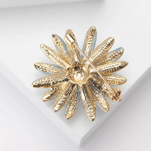 Macro shot of the textured gold metal finish and pin fastener on the daisy brooch