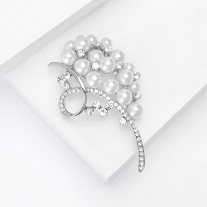 Detail of flower-shaped silver brooch with lustrous white pearls and shimmering rhinestones