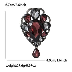 Detail view of vintage water drop brooch with deep red gems and sparkling crystals