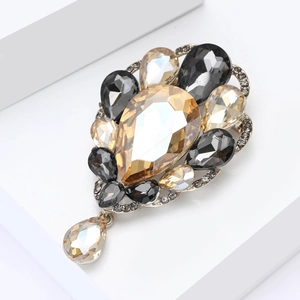 Detailed close-up of a vintage pear-shaped glass brooch with champagne crystal teardrops