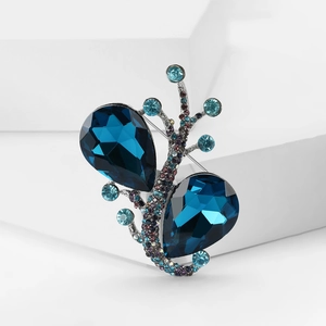 Detailansicht der eleganten Brosche mit tropfenblauen Kristallen und Strasssteinen