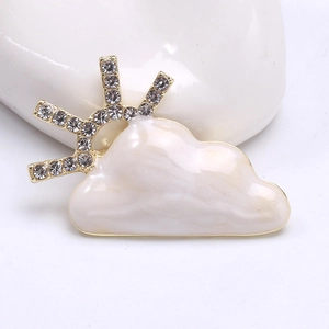 Detail of creative cloud and sun brooch featuring white enamel and sparkling zircons