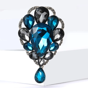 Macro view of blue crystal pendant brooch with silver base and droplet detail