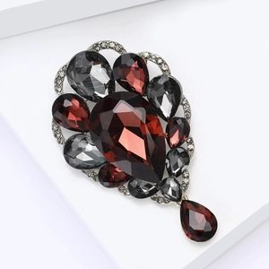 Elegant vintage brooch with red and grey crystals on a silver base for evening dresses