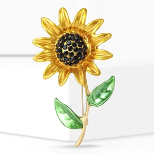 Broche tournesol élégante avec pétales dorés, cristaux noirs et feuilles émaillées
