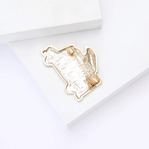 Detail view of the secure safety pin back on a gold-plated enamel cartoon brooch