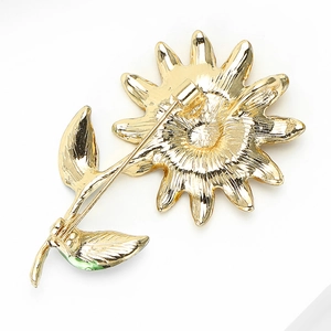 Détail du dos de la broche tournesol avec épingle de sûreté et feuilles en émail vert brillant