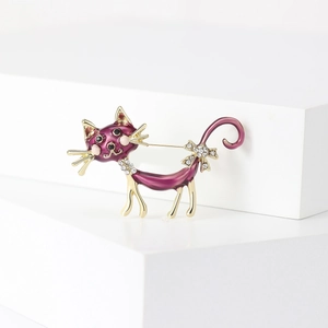Detailed view of long tail cat brooch featuring purple enamel and rhinestone bow decoration