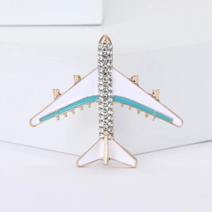 Elegant gold airplane brooch with sparkling rhinestones and white enamel finish