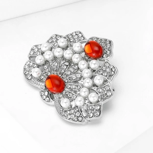 Détail de la broche fleur rétro avec perles, pierres rouges et cristaux brillants