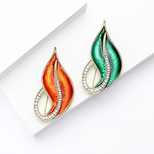 Elegant leaf-shaped enamel brooches with crystals in vibrant orange and green colors