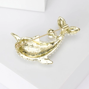 Golden dolphin brooch with white pearls showing the back clasp and metal craft details