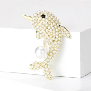 Elegant gold dolphin brooch paved with small white pearls on a minimalist pedestal