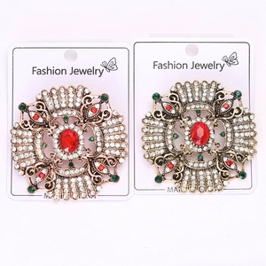 Detail of vintage baroque brooches with red gemstones and white sparkling rhinestones