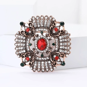Close-up of Baroque vintage brooch with red center stone and multicolor rhinestones